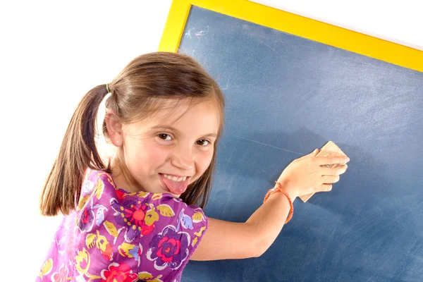 Schoolgirl writing on a blackboard — Stock Photo, Image