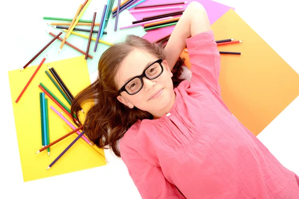 Colegiala acostada en el suelo con lápices de color — Foto de Stock