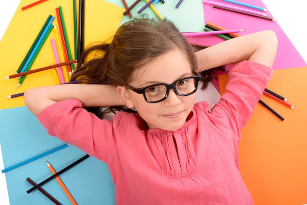 Školy dívka leží na podlaze s barevné tužky — Stock fotografie