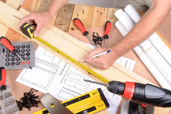 a man made a piece of furniture with various carpentry tools