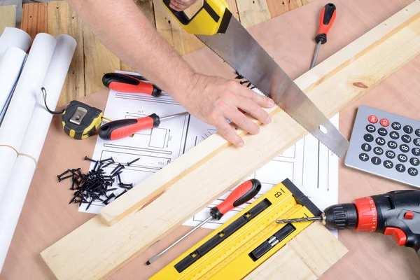 Ein Mann fertigte ein Möbelstück mit verschiedenen Tischlerwerkzeugen an — Stockfoto