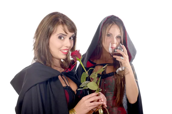 Dos mujeres jóvenes disfrazadas de halloween con un vaso de sangre y —  Fotos de Stock