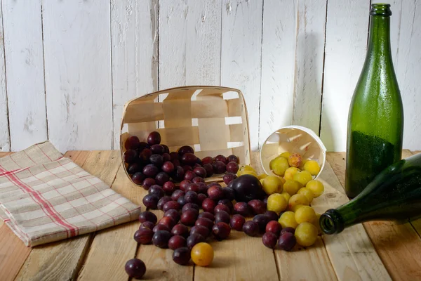 Prunes rouges et jaunes sur une table en bois — Photo