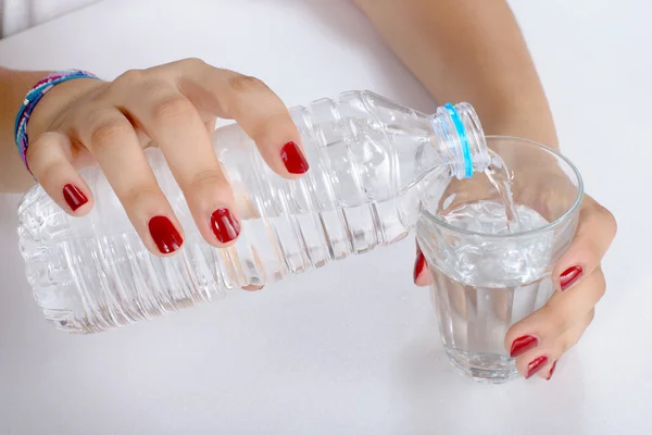 En ung kvinna fyllde ett glas vatten — Stockfoto