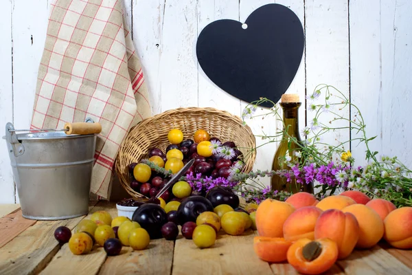 Albaricoques y ciruelas sobre una mesa de madera con corazón — Foto de Stock