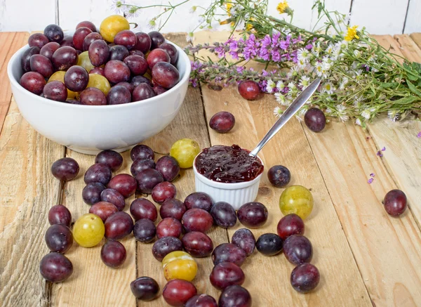 Red and yellow plums on a wooden table — Stock Photo, Image