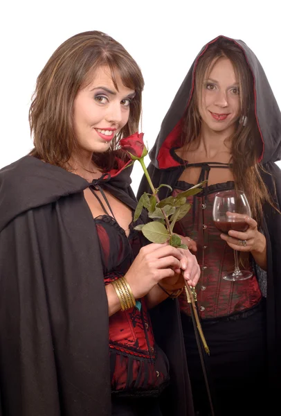 Two young women in disguise halloween with a glass of blood and — Stock Photo, Image