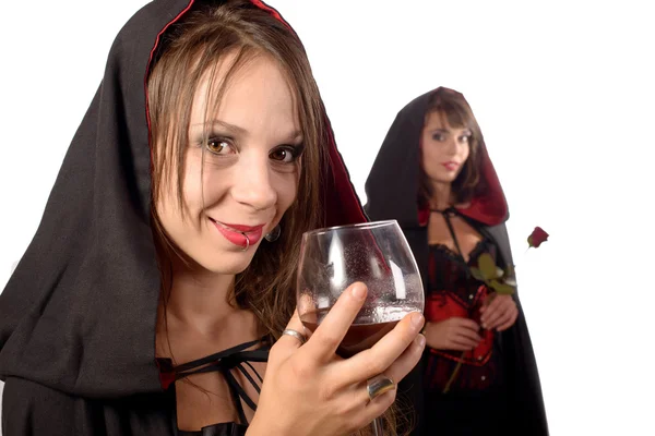 Duas jovens mulheres disfarçadas halloween com um copo de sangue e — Fotografia de Stock