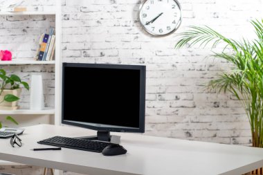 Beyaz masada bir bilgisayar var.