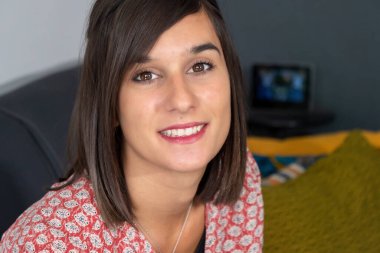 Gülümseyen esmer bir kadının portresi.