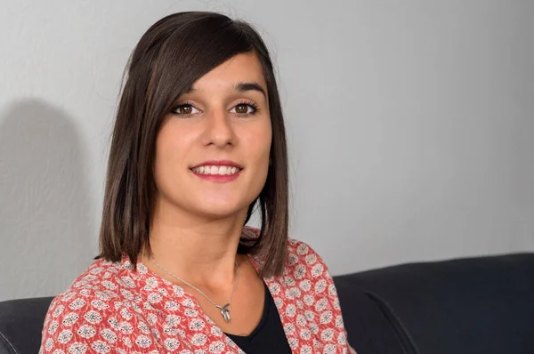 Gülümseyen esmer bir kadının portresi.