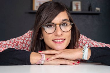 Gözlüklü, gülümseyen güzel bir esmer.