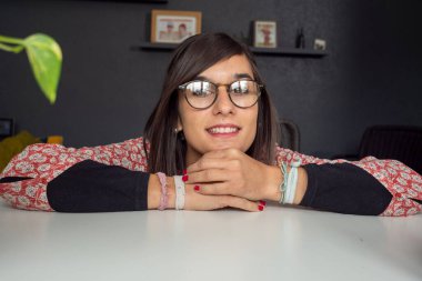 Gözlüklü, gülümseyen güzel bir esmer.