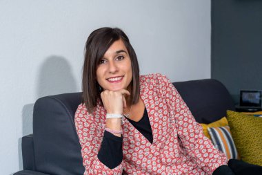 Gülümseyen esmer bir kadının portresi.