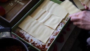 Kadın mutfakta lazanya hazırlıyor.