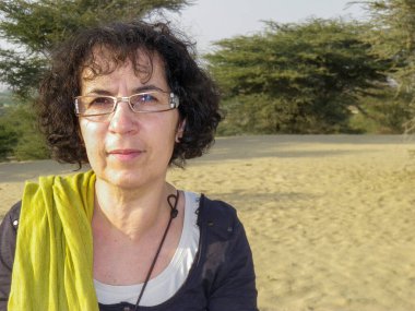 Açık havada oldukça olgun bir kadının portresi.