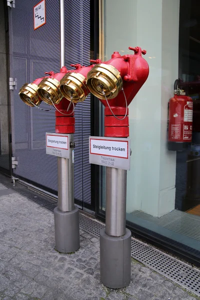001 Shiny metal red water plug with seals and plugs on the street, Красный блестящий металлический пожарный кран  с пломбами и затычками на улице — Stock Photo, Image