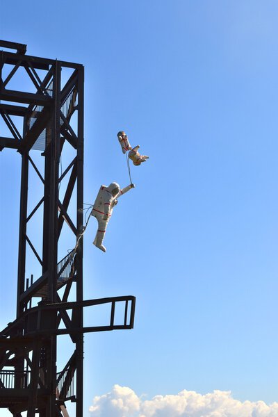 Космонавт выгуливает собак Белку и Стрелку в космосе.
