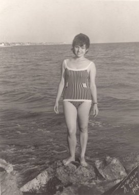 Rusya-TOPKI, 2020: Karadeniz kıyısında çizgili mayo giymiş bir kız. 1967 'den kalma siyah beyaz bir fotoğraf.