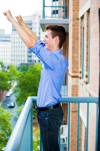Успешный парень поднимает руки, празднуя успех — стоковое фото