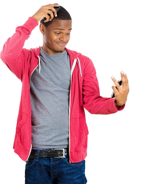 Retrato de cerca de un joven gallito guapo que mira admirando su cara y peinando el pelo delante del espejo de bolsillo — Foto de Stock