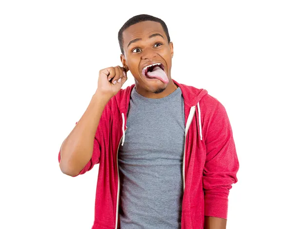 Nahaufnahme Porträt eines hysterischen Wahnsinnigen, der die Zunge herausstreckt, nach dem Ohr greift und verwirrt komische Gesichter zeigt — Stockfoto