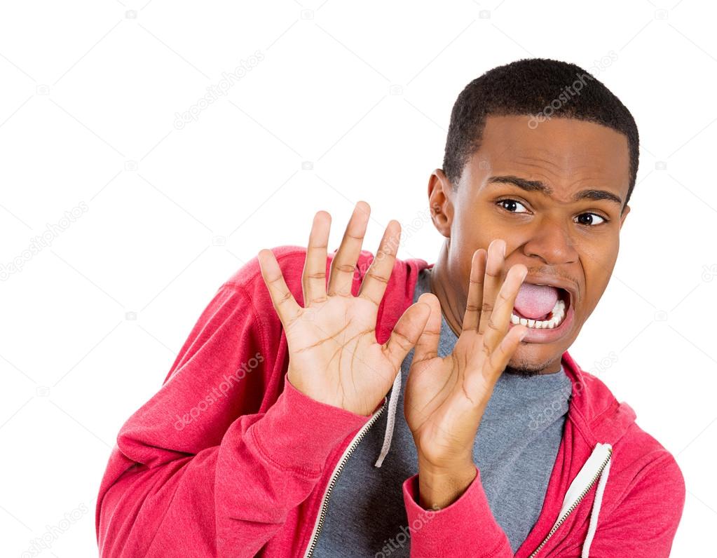 Closeup portrait of young man, looking shocked, scared trying to protect himself in anticipation of an unpleasant situation