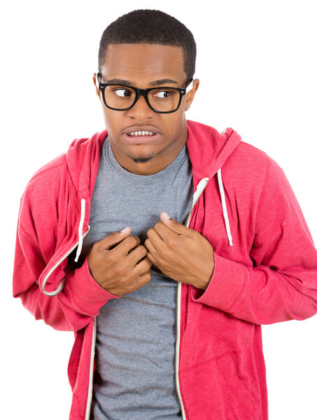 Closeup portrait of a young nerdy looking man with glasses, very timid, shy and anxious, playing with hands nervously