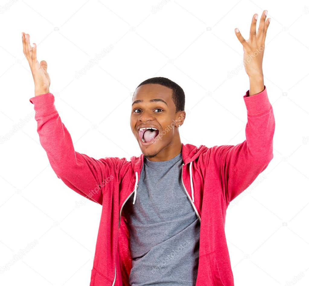 Closeup portrait of super happy excited smiling young man in red hoody with hands up in air