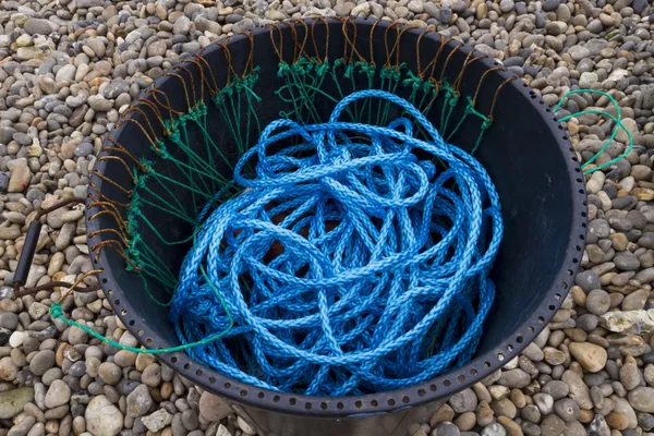 Corde en nylon bleu, poubelle noire, plage de galets — Photo