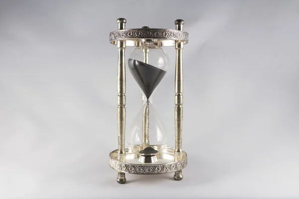 Hourglass - old fashioned hourglass, black sand, half full. — Stock Photo, Image