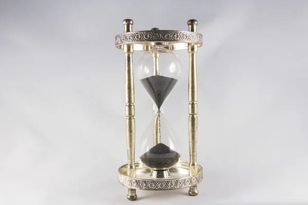 Hourglass - old fashioned hourglass, black sand, half full. — Stock Photo, Image