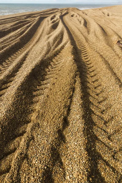 Caterpillar Tracks from digger on stony beach — Stock Photo, Image