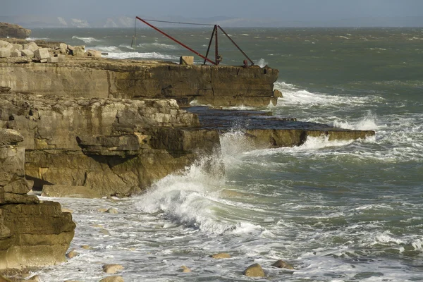 Olas, rocas y una grúa, Portland Bill — Foto de Stock