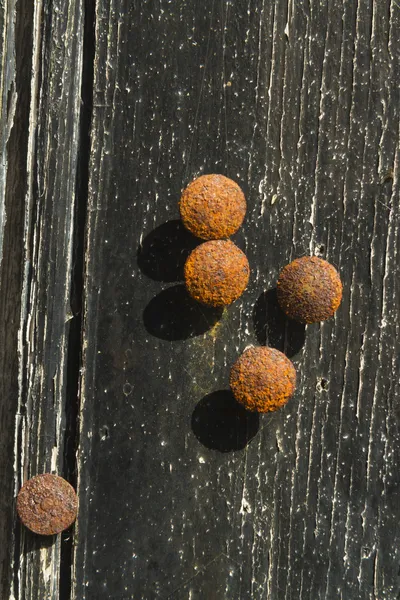 Alfileres de dibujo oxidados o tachuelas de pulgar contra una espalda de madera en dificultades — Foto de Stock
