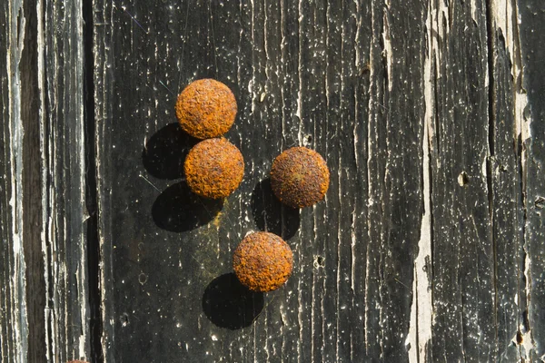 Rusty drawing pins or thumb tacks against a distressed wood back