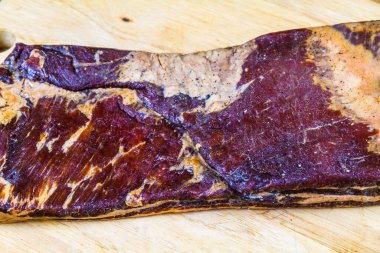 Domuz eti kuru kurutuldu ve hızlı bir pastırma olmak için tüttürüldü. Tahtada, manzarada, kapat.