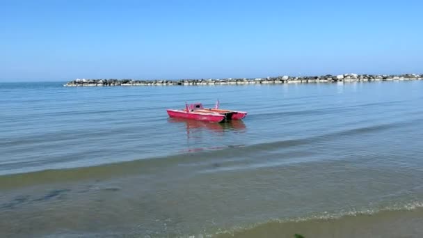Bote de rescate rojo flotando en el agua — Vídeos de Stock