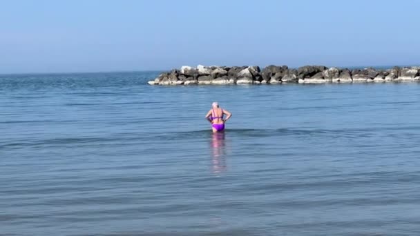 Adriatic Riviera. Elderly woman walking in the sea. — Vídeo de Stock