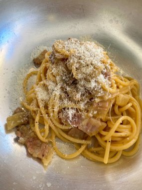 Pastırma veya pancetta, yumurta ve parmesan peynirli Carbonara soslu güzel ve davetkar bir spagetti. Tipik İtalyan makarnası doğrudan tavadan servis edilir..