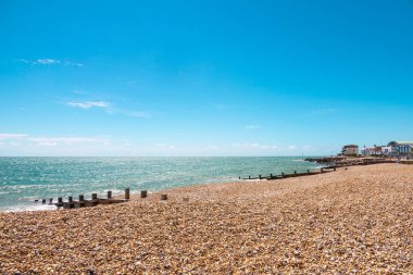 Mavinin tonları. İngiltere 'nin güney kıyısında bir gün, Felpham' da, Brighton yakınlarında. Çakıl taşları ve kayalardan oluşan kumsal manzarası, açık mavi deniz ve gökyüzü, güneşli bir gün. İngiltere 'de güzel bir yaz günü.