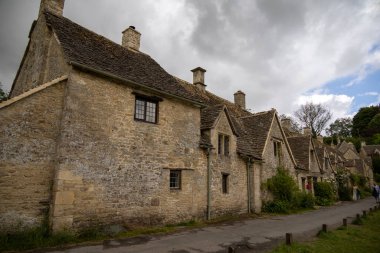 Bibury, UK, 28 june 2022. Charming cottages in Arlington Row in Bibury with River Coln, Cotswolds, Gloucestershire, UK. Moody weather, british summer atmosphere.