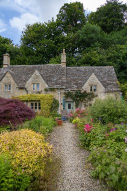 Bibury, UK, 28 june 2022. Charming cottages in Arlington Row in Bibury with River Coln, Cotswolds, Gloucestershire, UK. Moody weather, british summer atmosphere.