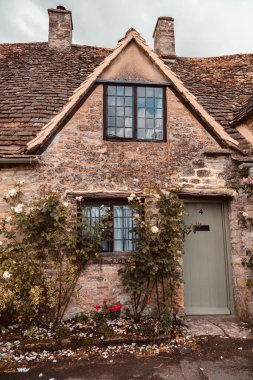 Bibury, UK, 28 june 2022. Charming cottages in Arlington Row in Bibury with River Coln, Cotswolds, Gloucestershire, UK. Moody weather, british summer atmosphere.