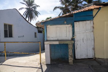 Dominik Cumhuriyeti 'ne yolculuk, Pedernales' ten Santo Domingo 'ya. Tipik fakir ahşap barakalar ya da parlak renklere boyanmış evler, palmiye ağaçları..