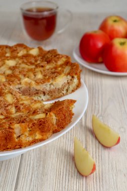 Elmalı turta ahşap bir masada kırmızı elmaların arka planına karşı..