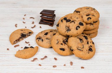 Tahta bir masada çikolata parçalı kurabiyeler.