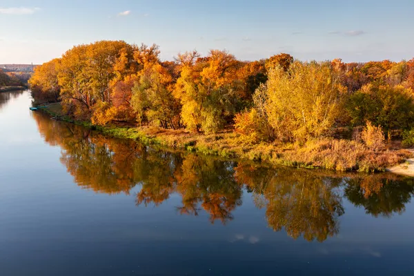 Paisagem de outono. Cores brilhantes do outono junto ao rio. Árvores de outono multicoloridas ao sol na margem do rio. — Fotografia de Stock
