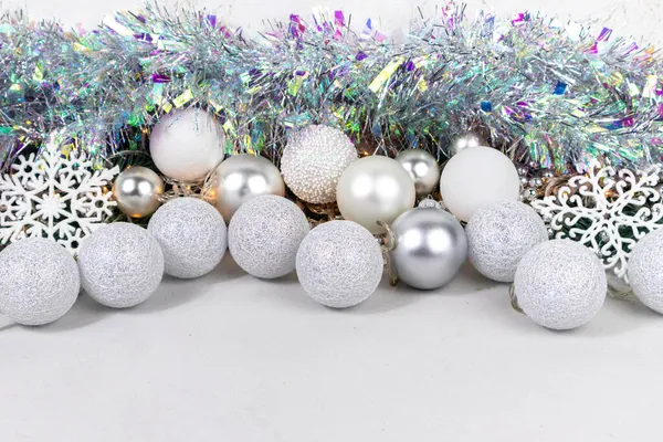 Christmas card with white and silver balls, garland, tinsel, snowflakes on a white background. Royalty Free Stock Photos