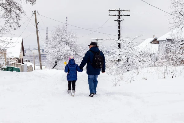Baba ve kızı kış günü karlı bir yolda yürüyüşe çıkarlar. Kış eğlencesi